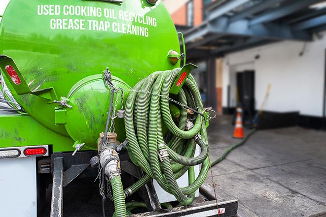 a technician pumping a grease trap in a commercial building in Argyle TX